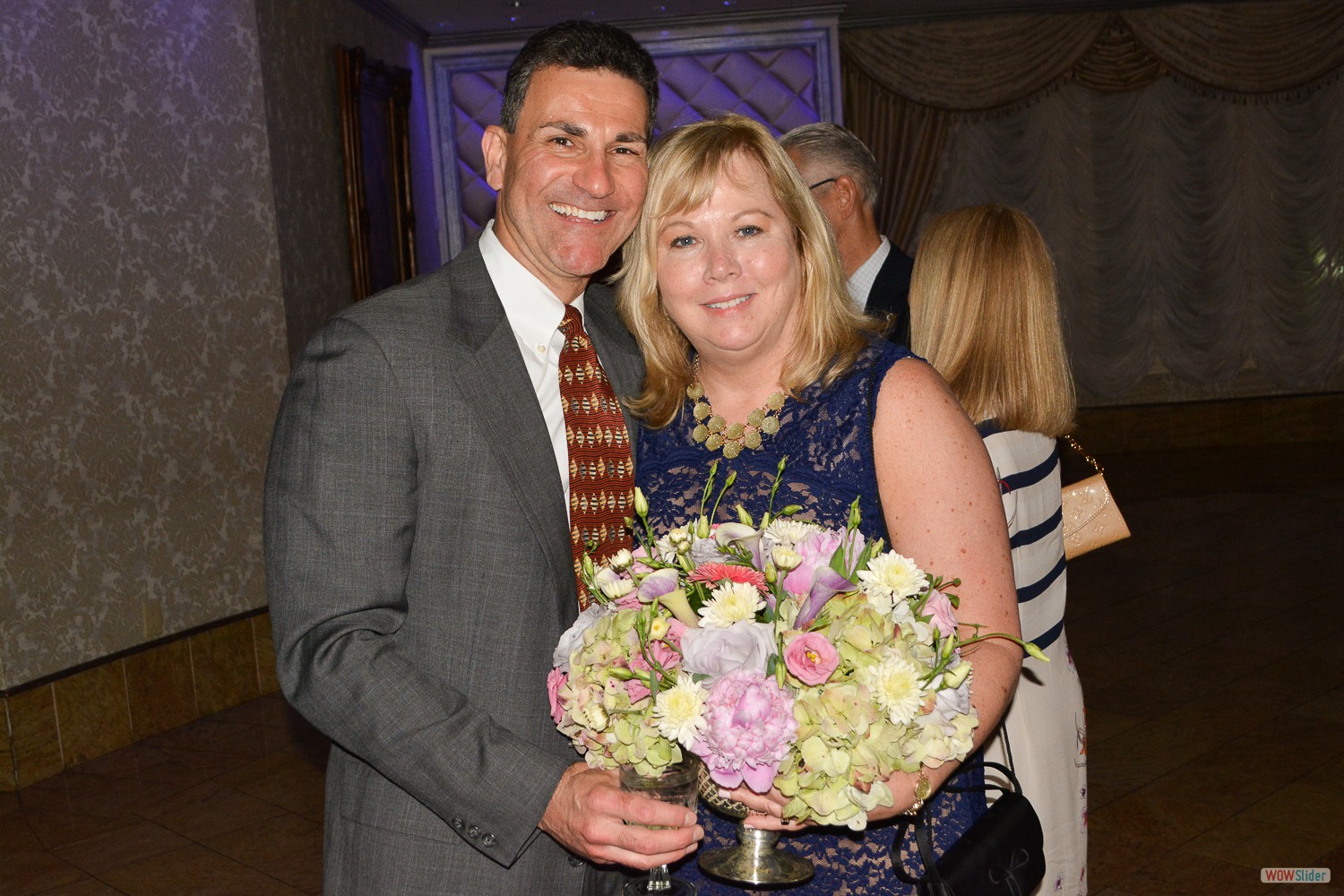 Chapter Past President Maureen Kalena joins Bob Pabst with a floral bouquet.