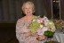 Janet McCourt is happy to pose with a floral bouquet.