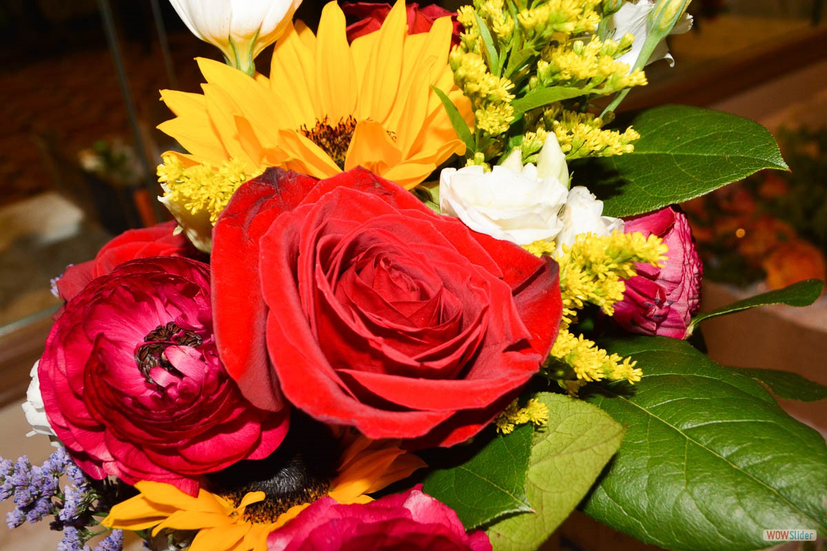 A bright red rose and yellow sunflower with red and white floral accents adourn the reception.