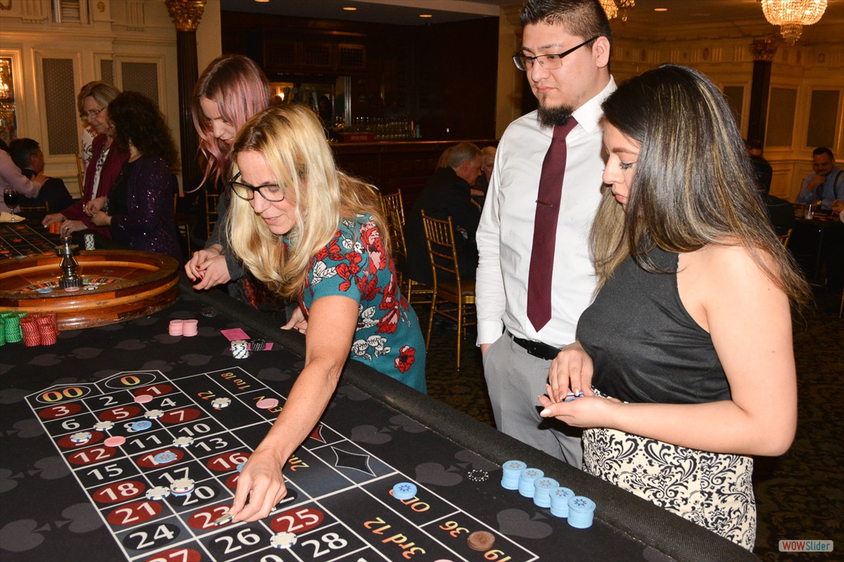 Chapter Treasurer Amy Wheatley (c.) places a sure bet at the roulette table.