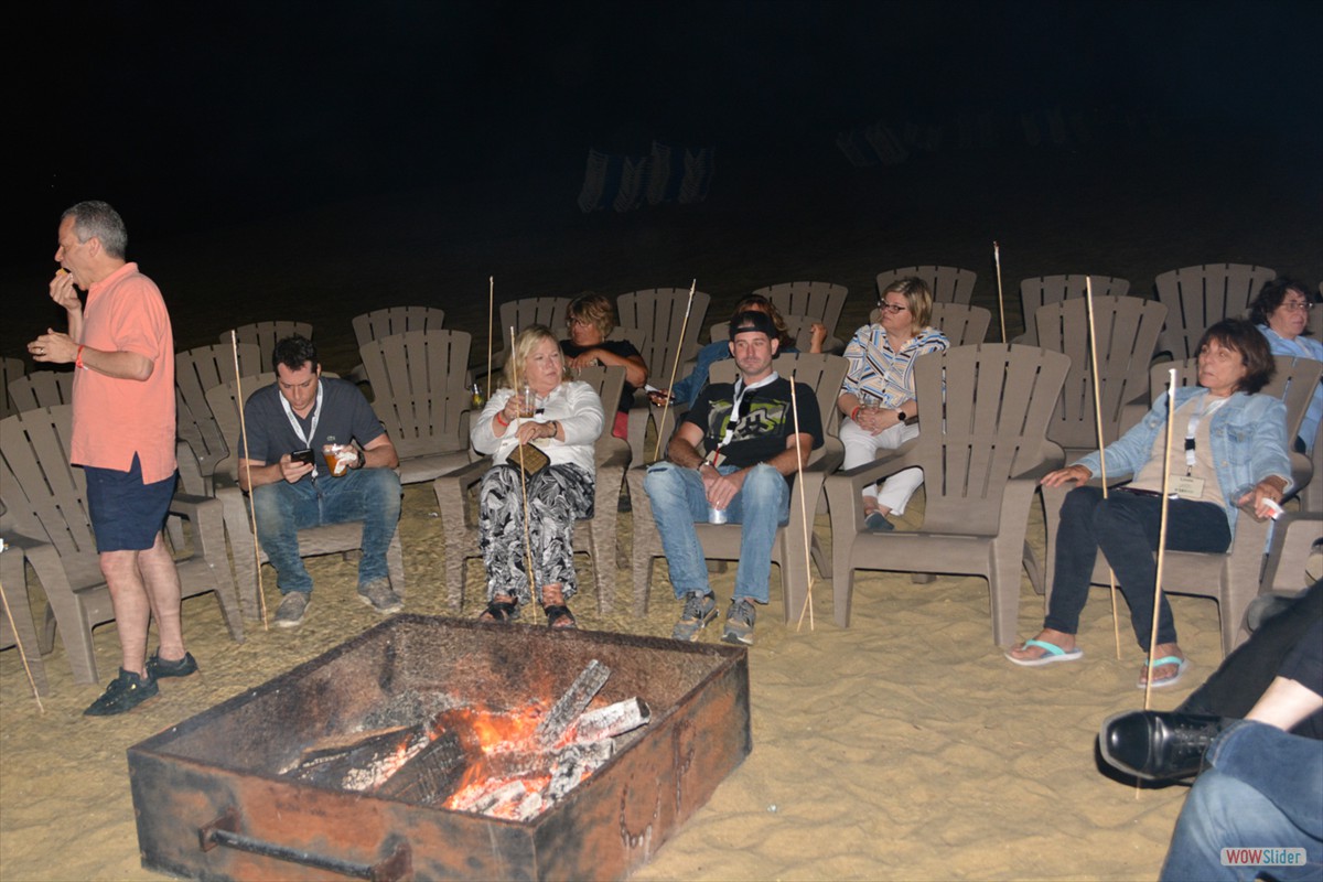 Members and guests roast marshmellows around the bonfire.